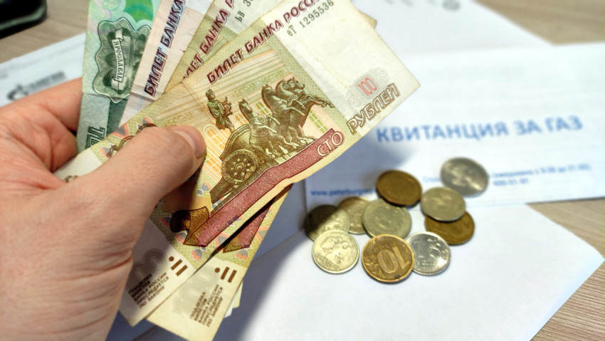 Человек держит пачку денег в руке