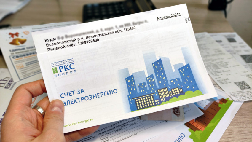 Человек держит счет за электроэнергию с изображением города