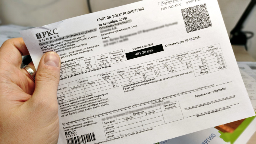 Счет за электроэнергию с QR-кодом в руке