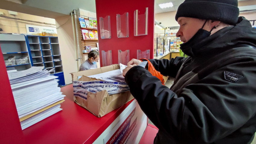 Посетитель почтового отделения сортирует письма