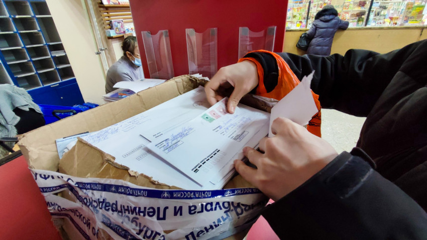 Клиент на почте перебирает корреспонденцию, чтобы найти свое письмо среди других