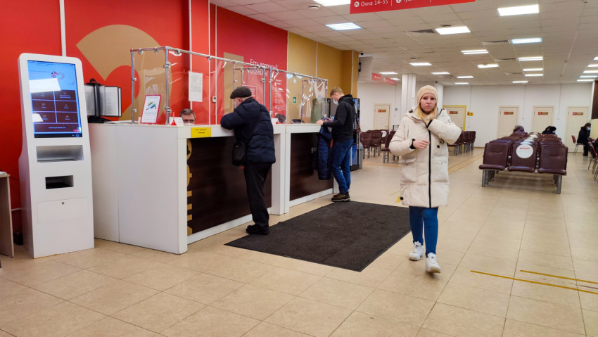 Люди у информационной стойки в МФЦ