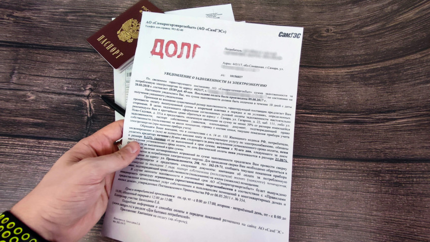 Уведомление о долге за электроэнергию в руке человека