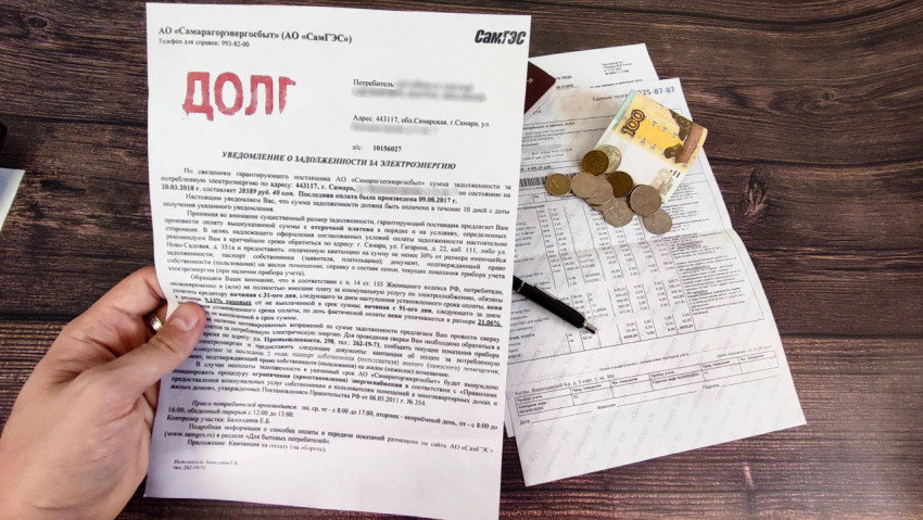 Уведомление о задолженности по электроэнергии на фоне квитанции и денег