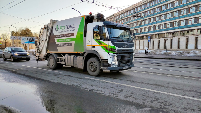 Грузовик для вывоза мусора едет по улице