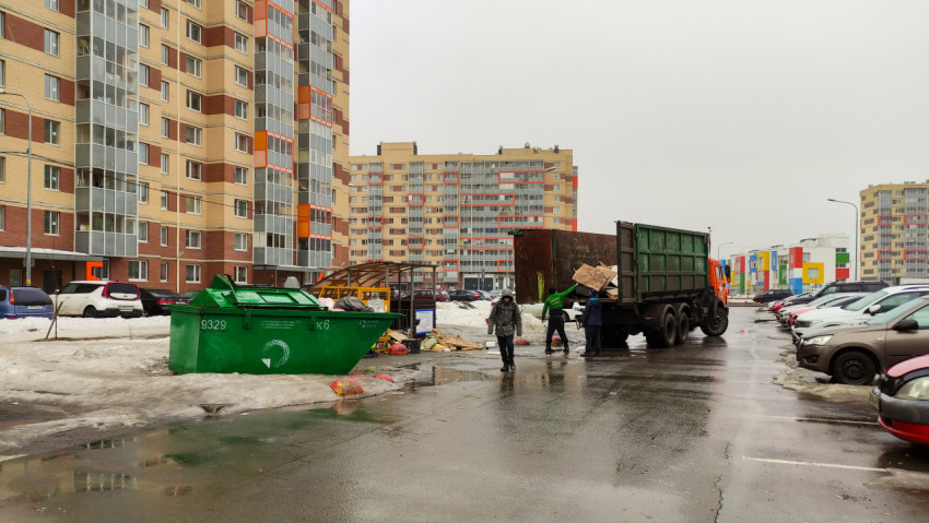 Рабочие коммунального хозяйства вывозят мусор в жилом районе