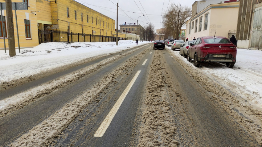 Зимняя улица с припорошенным снегом и следами автомобилей