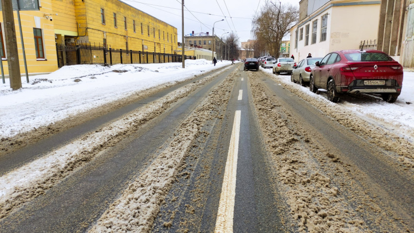Зимняя улица с сугробами и неубранным снегом в городе
