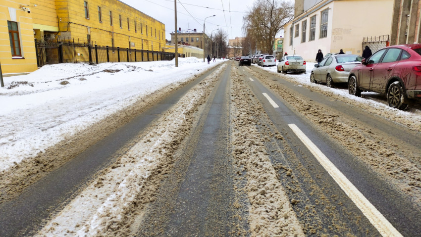 Зимняя улица со снегом и грязью в городском районе