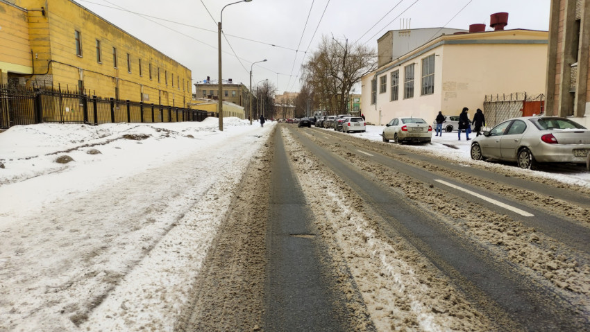 Зимняя улица в городе с заснеженными тротуарами и машинами