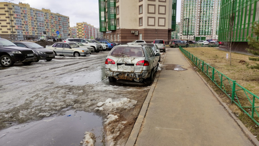Разбитый автомобиль на парковке в жилом районе