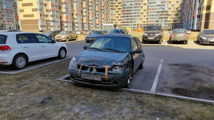 Поврежденный автомобиль на парковке возле жилого комплекса