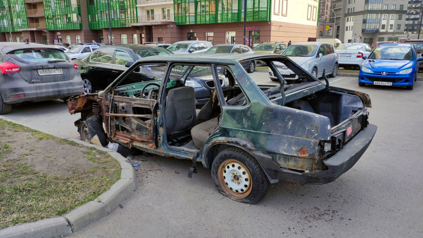 Сгоревшая машина на улице среди других автомобилей
