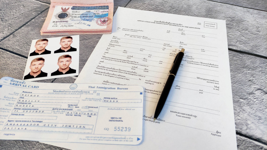 Документы для иммиграции в Таиланд на столе с паспортом