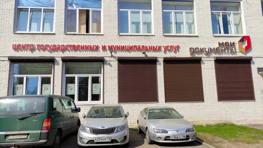 Фасад центра государственных и муниципальных услуг с припаркованными автомобилями