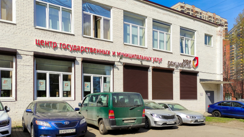 Здание МФЦ с припаркованными автомобилями на переднем плане