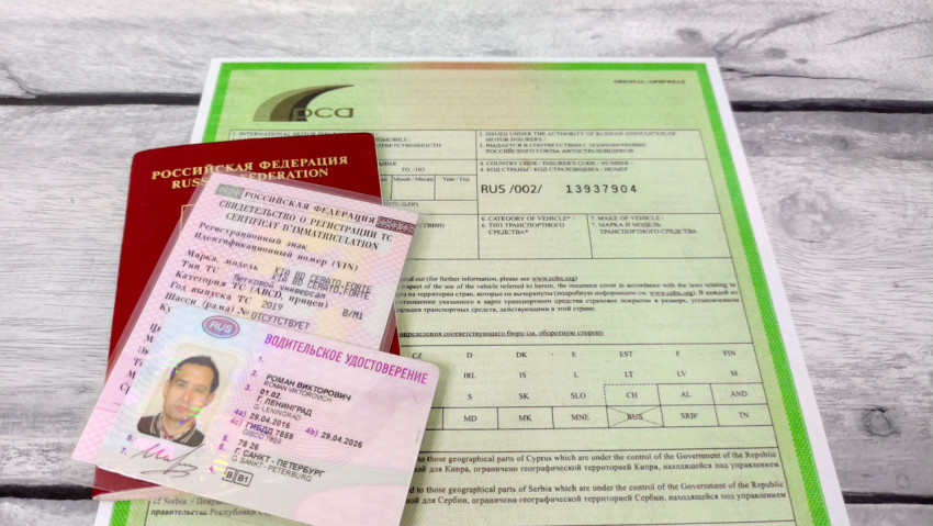Паспорт, водительские права и свидетельство о регистрации на фоне международной страховой карты