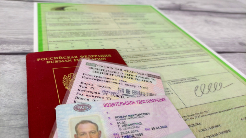 Паспорт, водительское удостоверение и свидетельство о регистрации на фоне зелёной карты