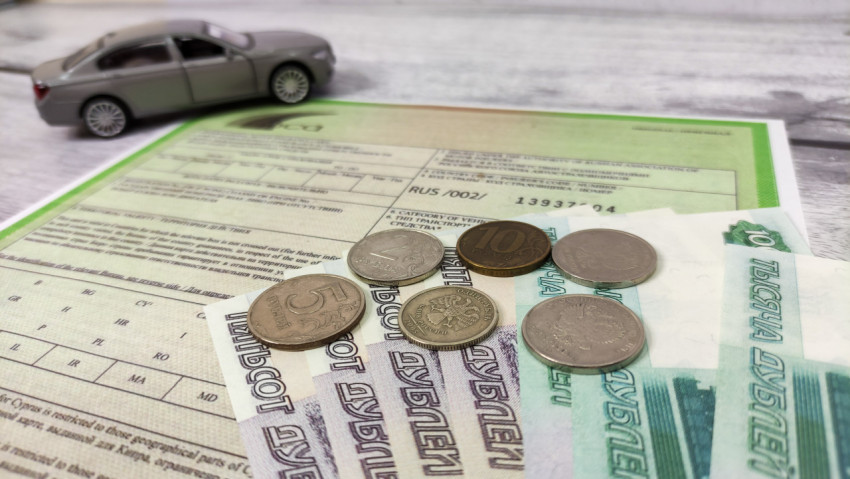 Деньги на зелёной карте и макет автомобиля на заднем плане