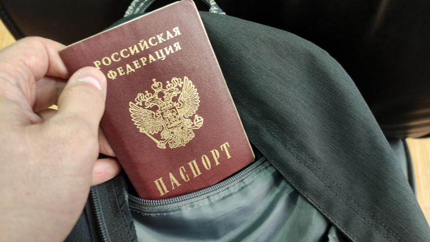 Паспорт РФ в руке у рюкзака