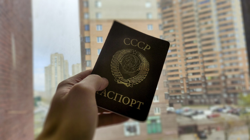 Паспорт СССР в руке на фоне жилых домов