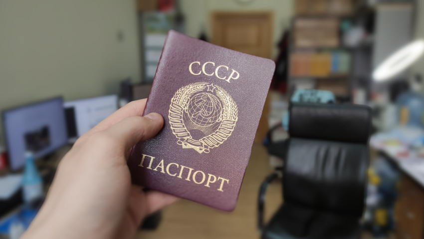 Паспорт СССР в руке на фоне рабочего кабинета