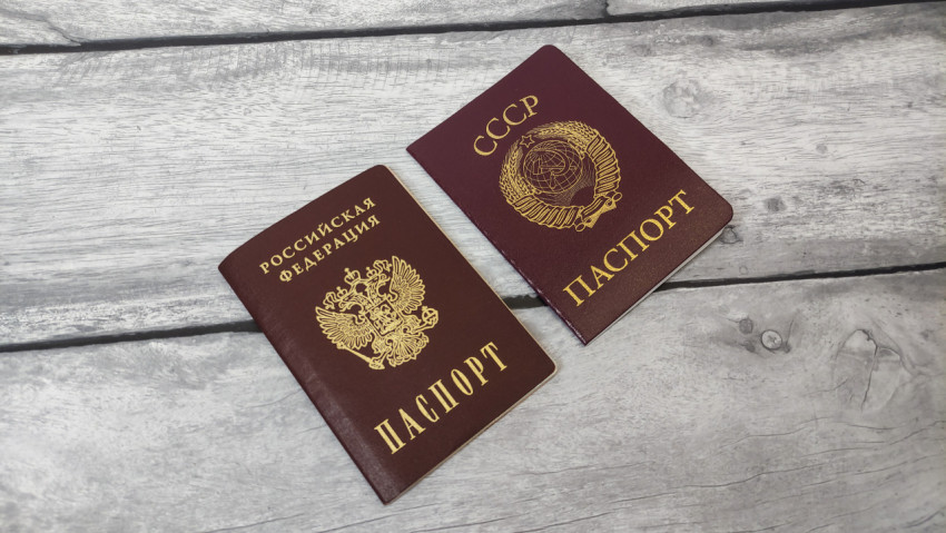 Паспорта Российской Федерации и СССР на деревянном фоне