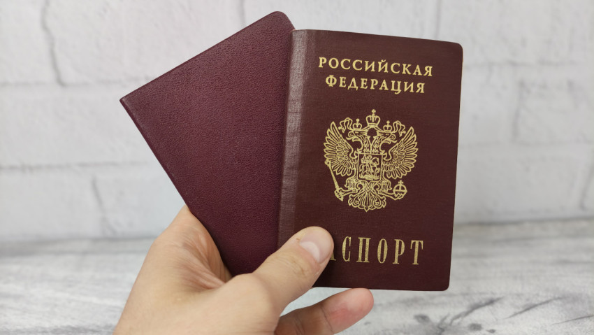 Паспорт РФ в руке на фоне светлого пола