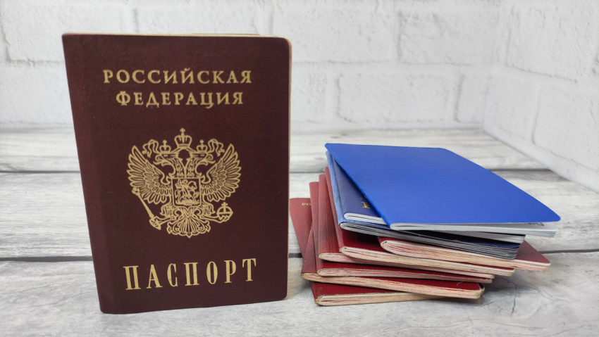 Паспорт РФ и стопка документов на фоне светлой стены