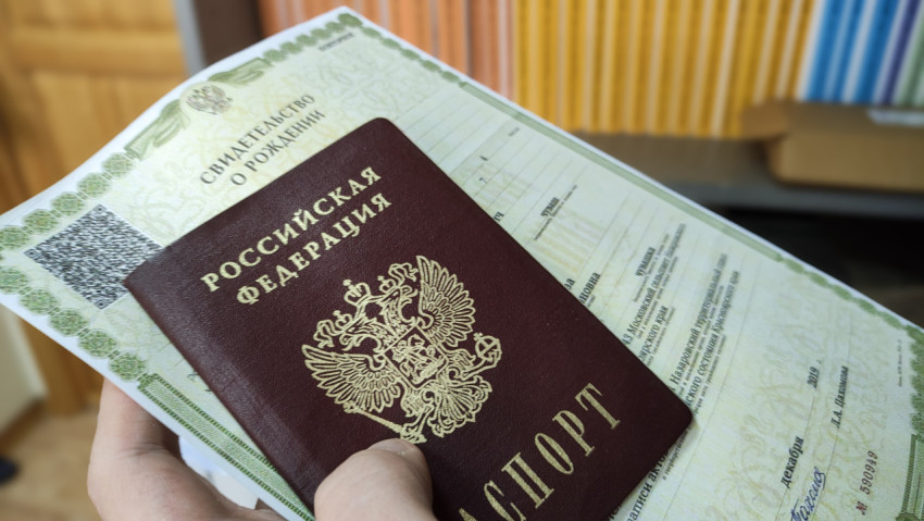 Паспорт РФ и свидетельство о рождении в руке