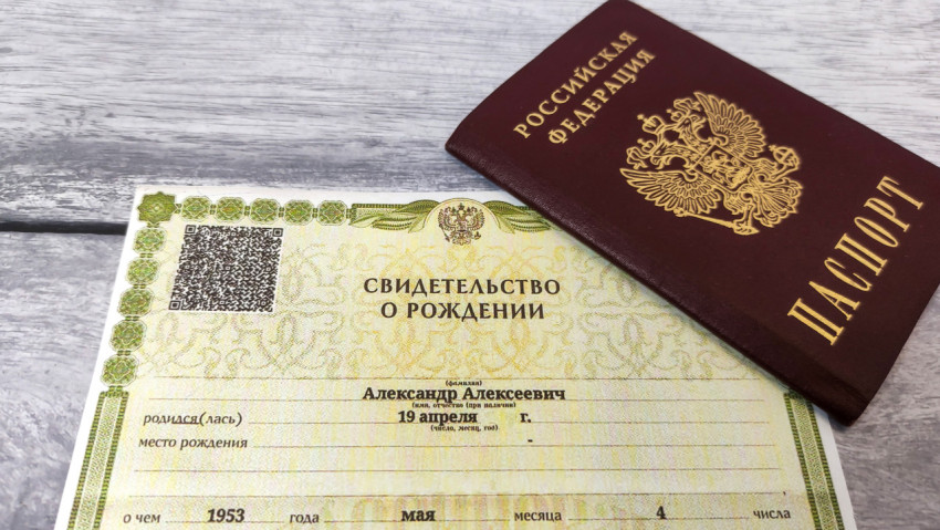 Свидетельство о рождении и паспорт РФ на деревянной поверхности
