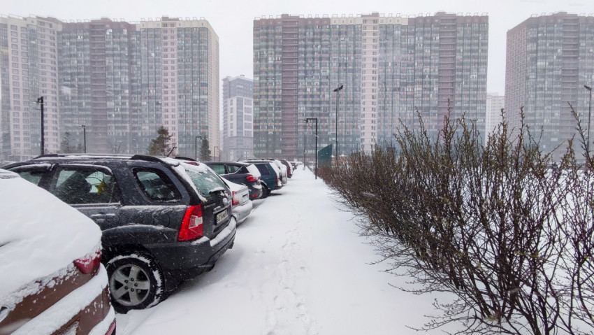 Парковка и жилые высотки в снегопаде