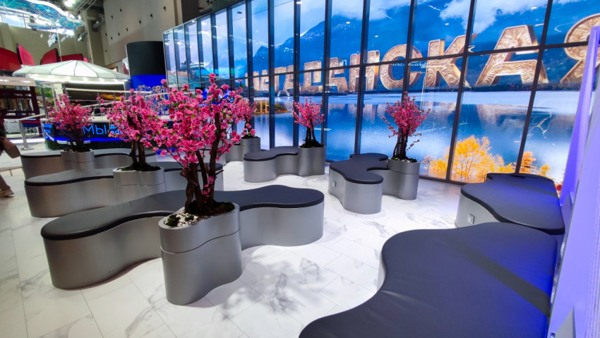 Зона отдыха с декоративными деревьями на стенде региона в павильоне №75