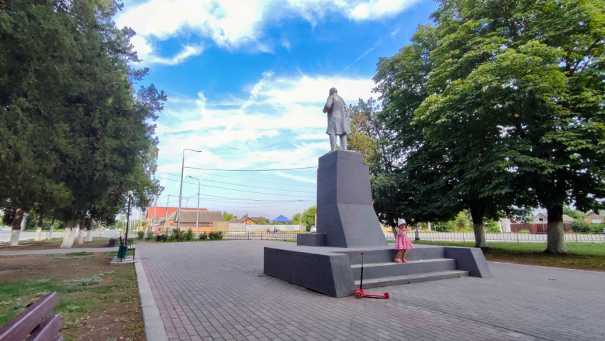 Памятник Ленину в городском сквере с ребёнком у постамента