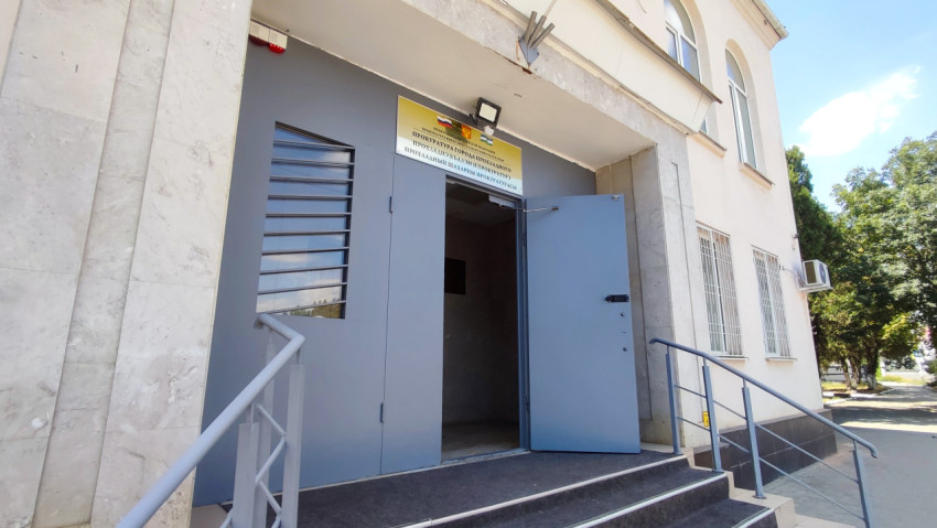 Вход в здание прокуратуры с пандусом и открытыми металлическими дверями