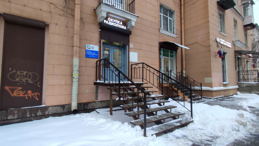 Поручень и лестница к магазину на фоне снежного двора в зимний день