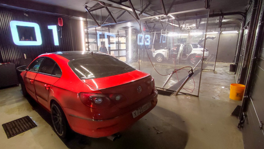 Автомойка в современном помещении с красным автомобилем