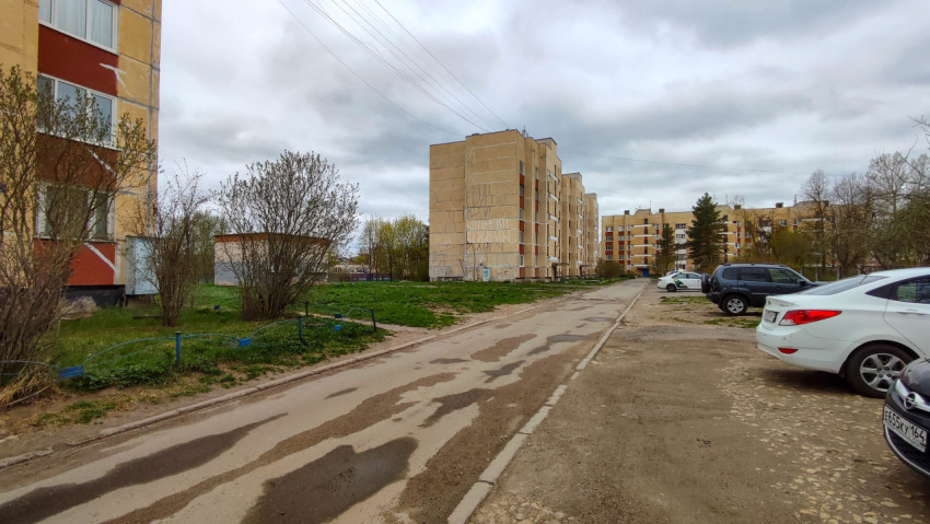 Двор жилых зданий с зелеными насаждениями и парковкой