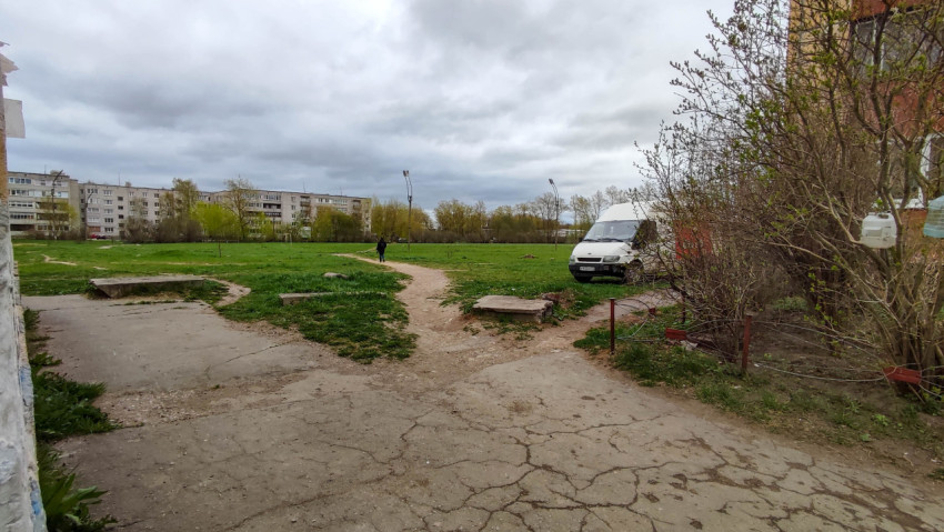 Парк в городе с зелени, автомобилем и облачным небом весной