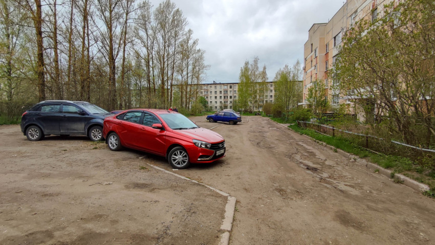 Парковка во дворе жилого дома с разными автомобилями