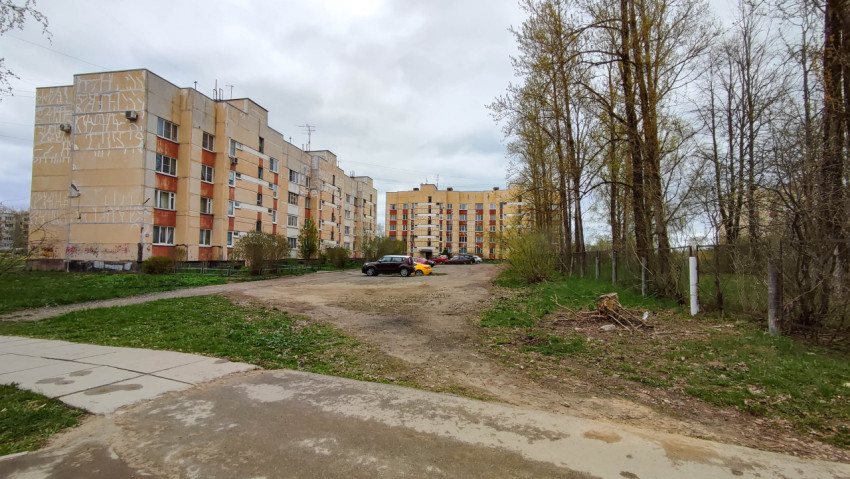 Двор многоквартирного дома с зелеными насаждениями и авто