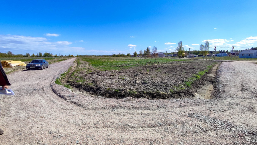 Грунтовая дорога в поле с ясным небом и зелеными участками