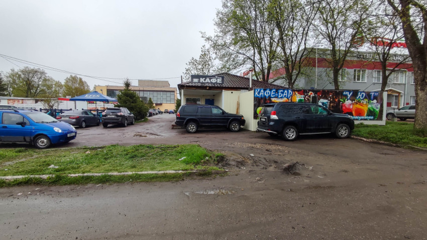 Кафе-бар на улице в дождливый день с парковкой для автомобилей
