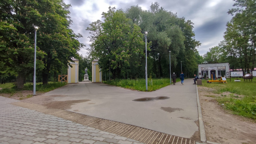 Прогулка по парку на фоне зелёных деревьев и облачного неба