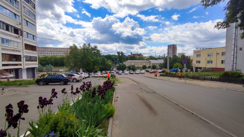 Улица города с цветами и облаками