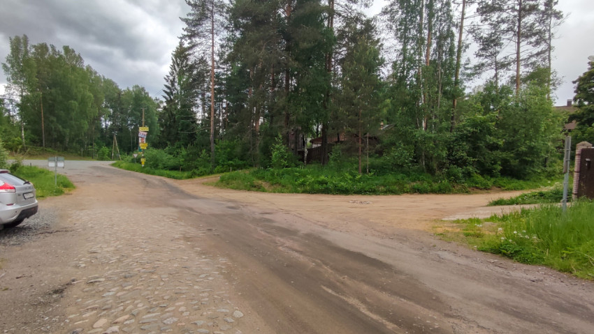 Перекресток между асфальтированной и грунтовой дорогой в поселке