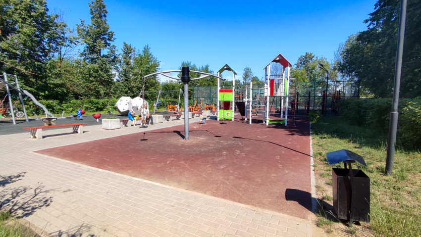Детская площадка с качелями и игровыми комплексами в солнечный день