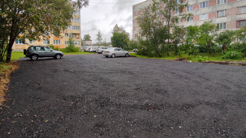 Просторная гравийная парковка во дворе жилых домов