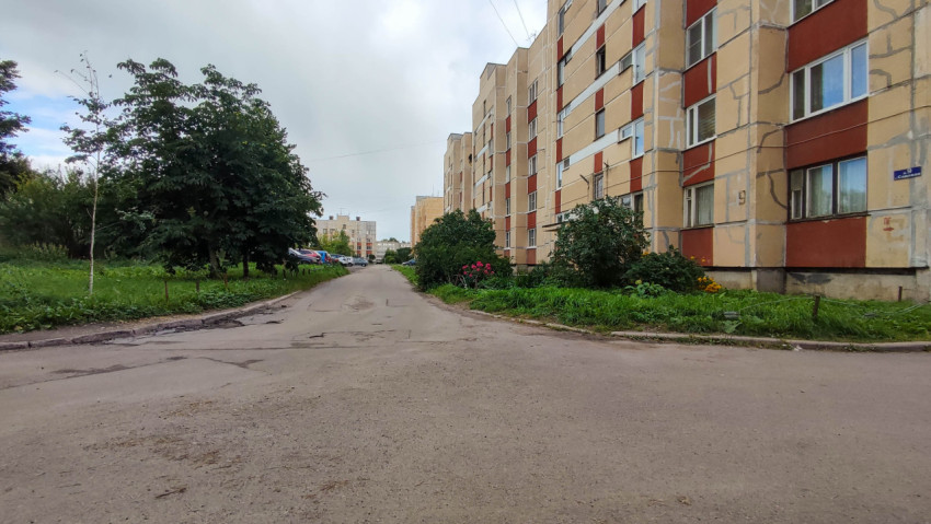 Тихий двор с многоэтажными домами и зелеными насаждениями
