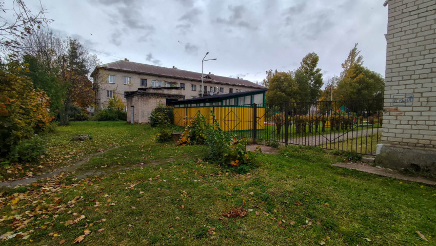 Двор с зелёной зоной, огороженной площадкой и жилым домом